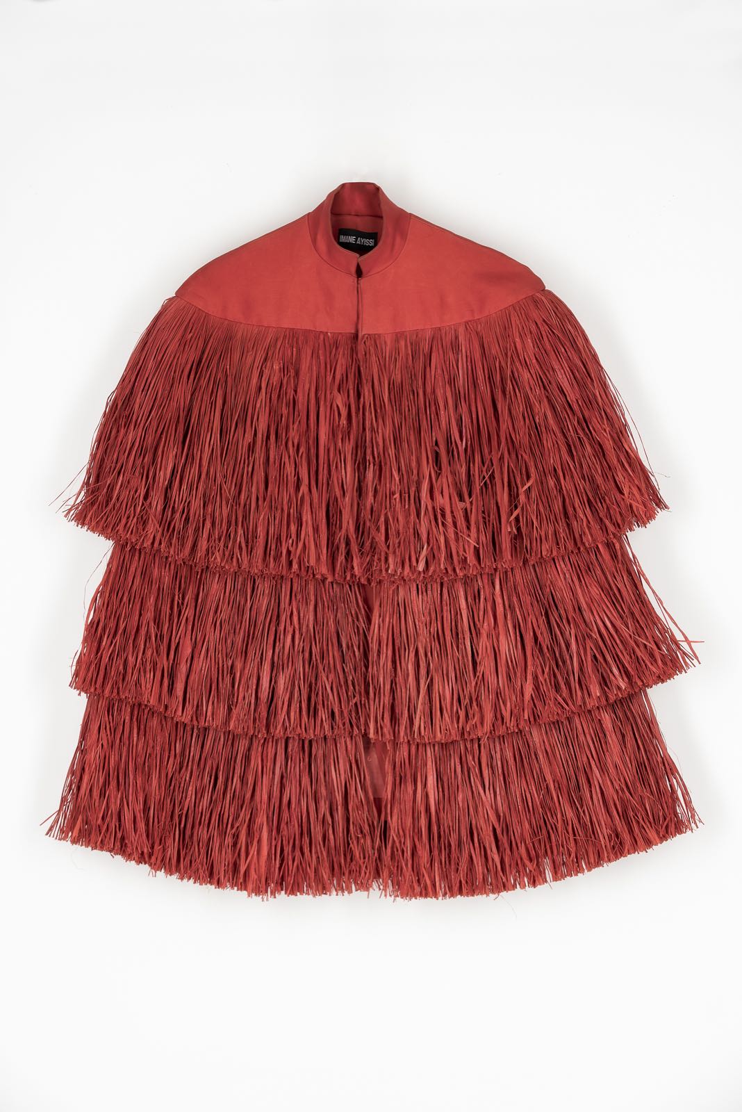 Flat photo of the fringed cape in silk and natural raffia